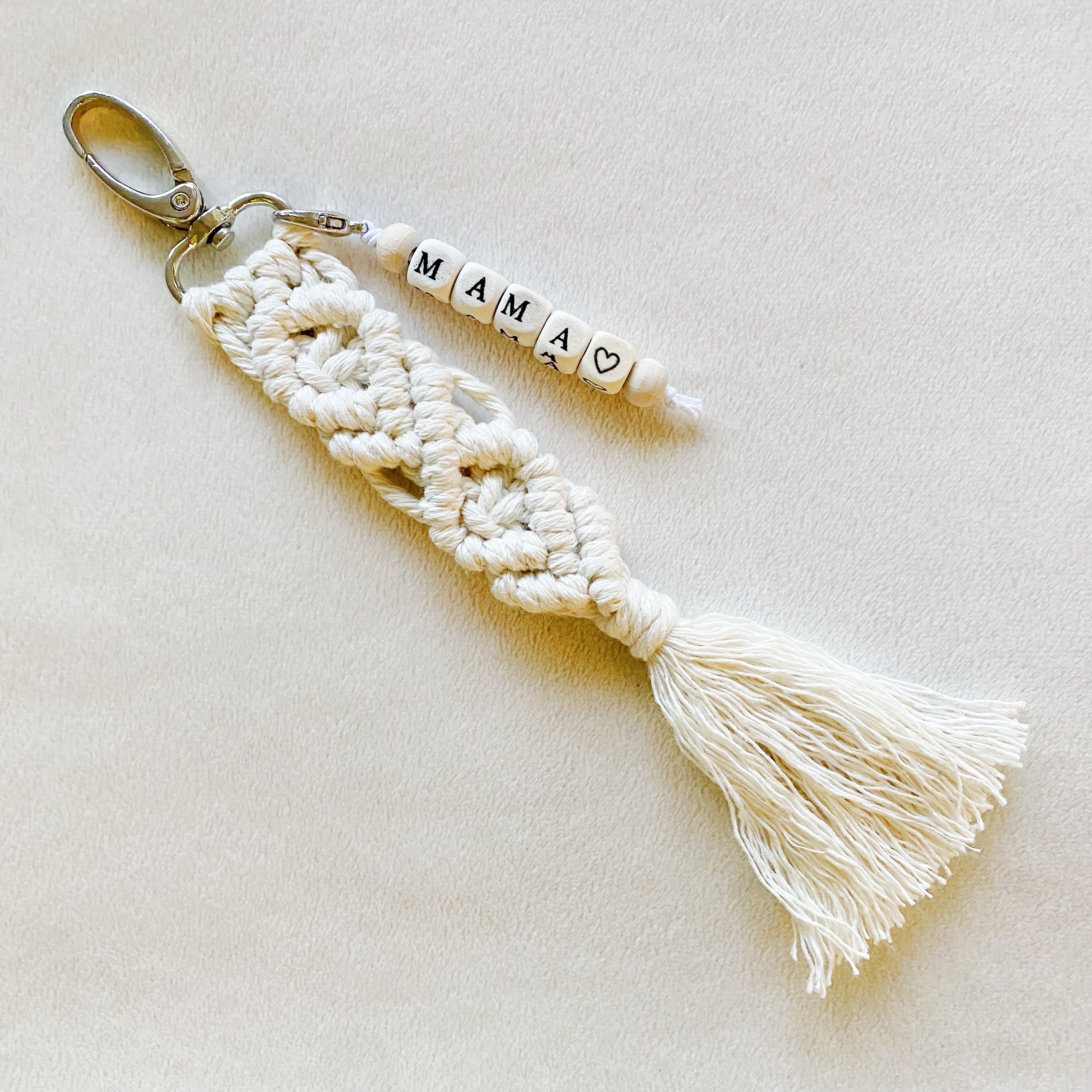 A stylish macrame braided key chain featuring empowering wooden cube beads, showcasing a bohemian design.