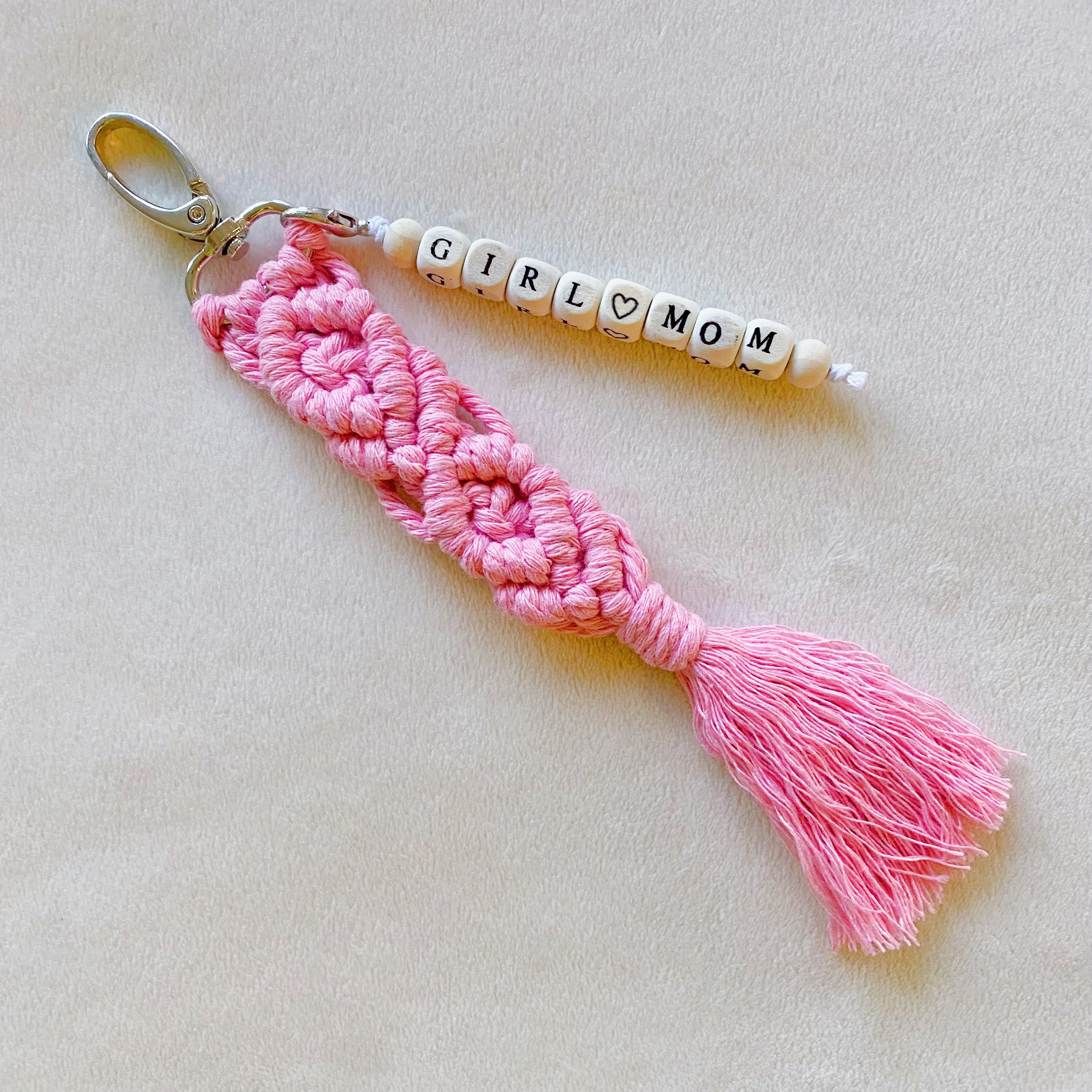 A stylish macrame braided key chain featuring empowering wooden cube beads, showcasing a bohemian design.