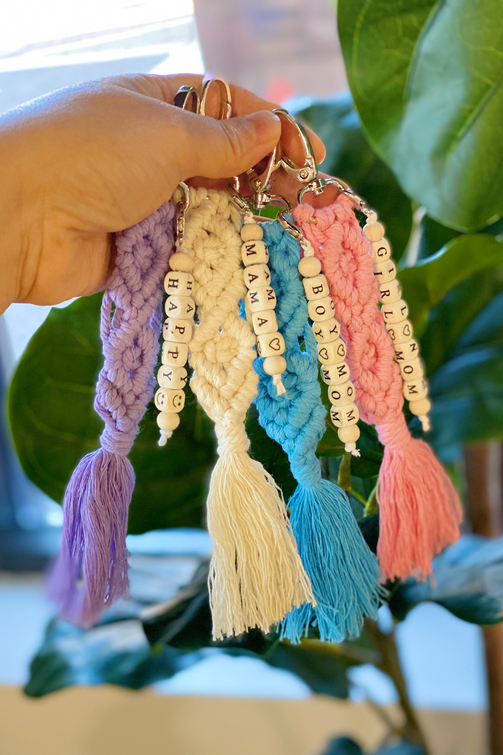 A stylish macrame braided key chain featuring empowering wooden cube beads, showcasing a bohemian design.