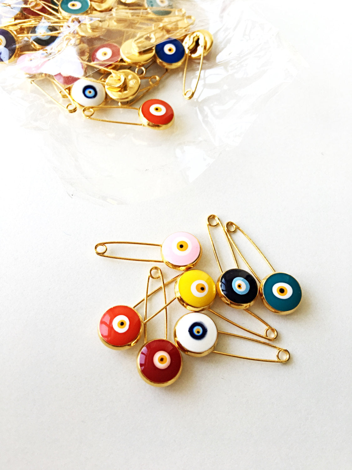 Gold plated lucky evil eye safety pin with big enamel eye, available in multiple colors for baby protection.