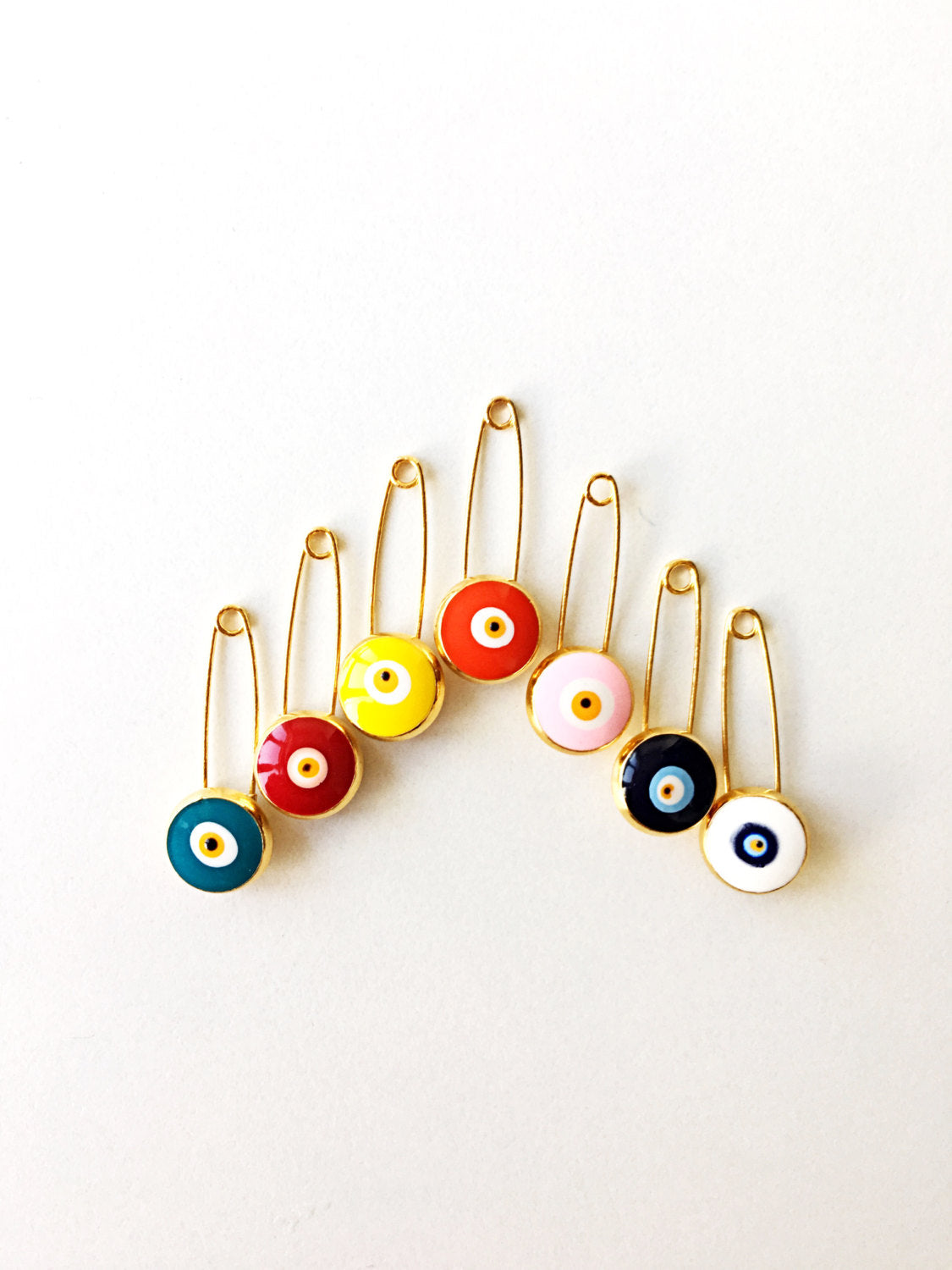 Gold plated lucky evil eye safety pin with big enamel eye, available in multiple colors for baby protection.