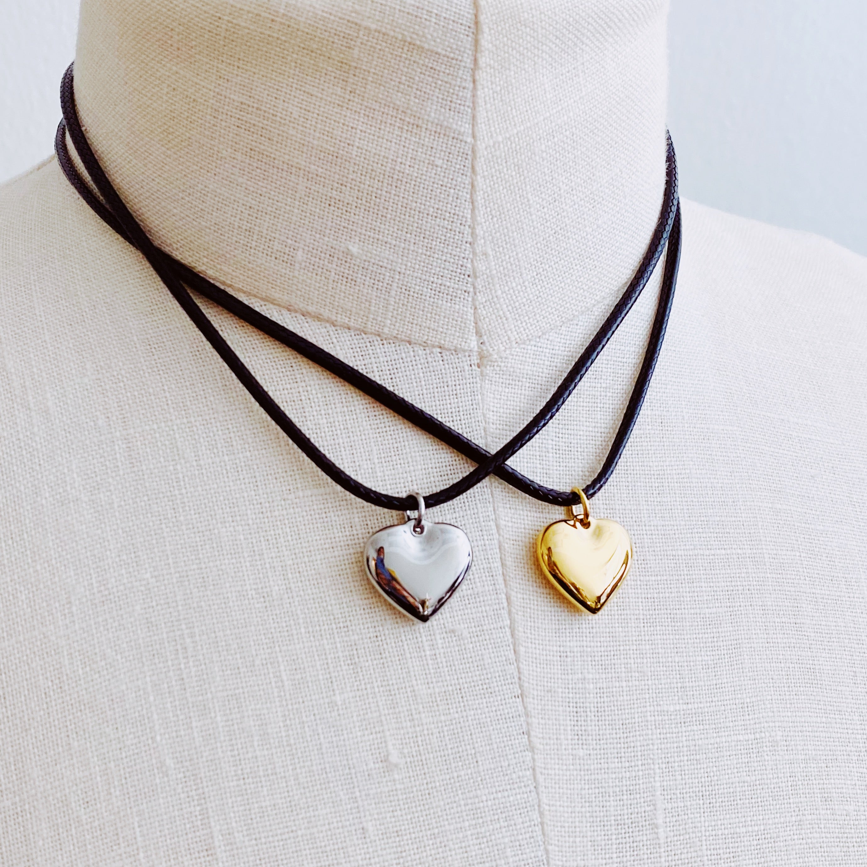 Black Cord Heart Drop Necklace featuring a stylish black cord chain and a rounded heart pendant, elegantly designed for versatile wear.