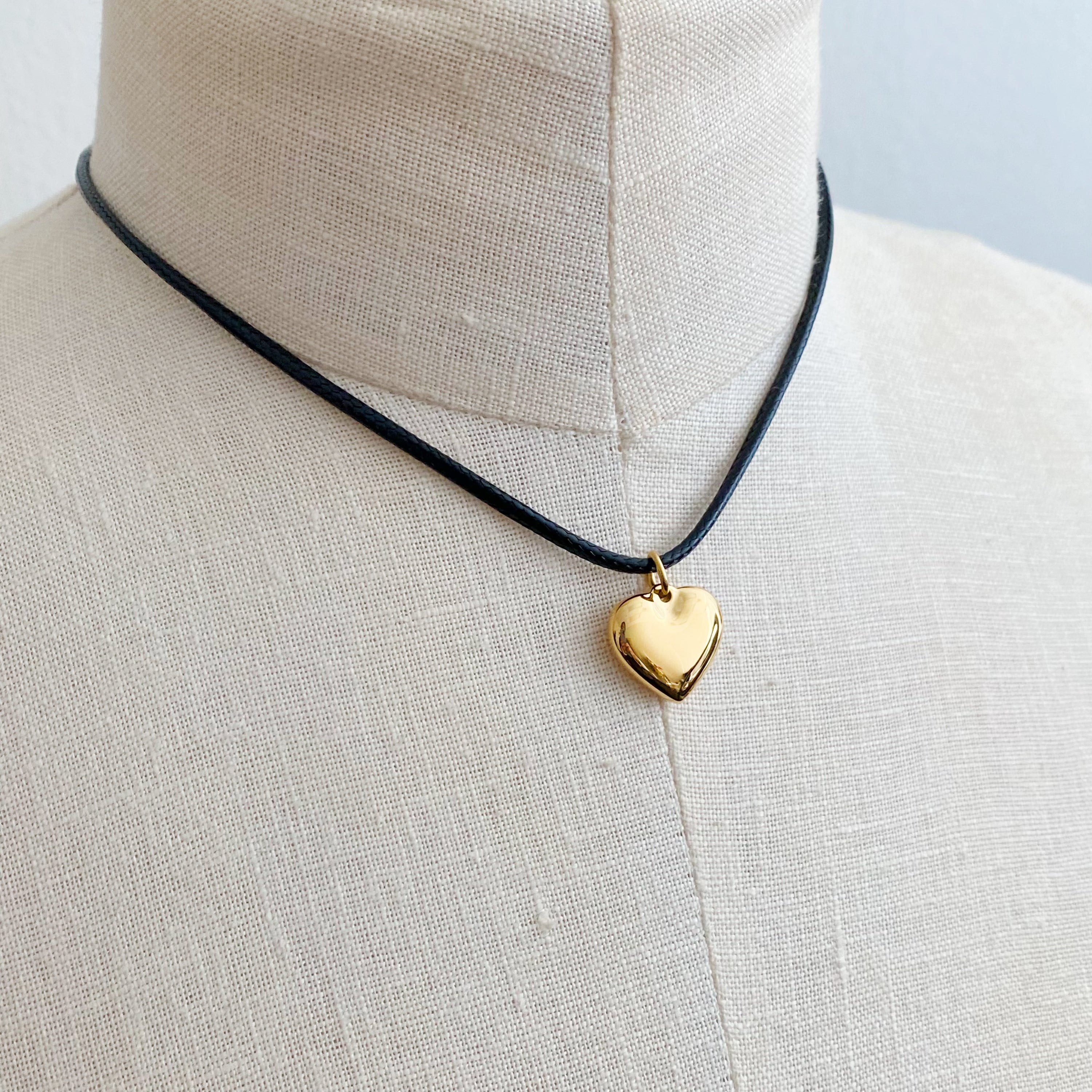 Black Cord Heart Drop Necklace featuring a stylish black cord chain and a rounded heart pendant, elegantly designed for versatile wear.