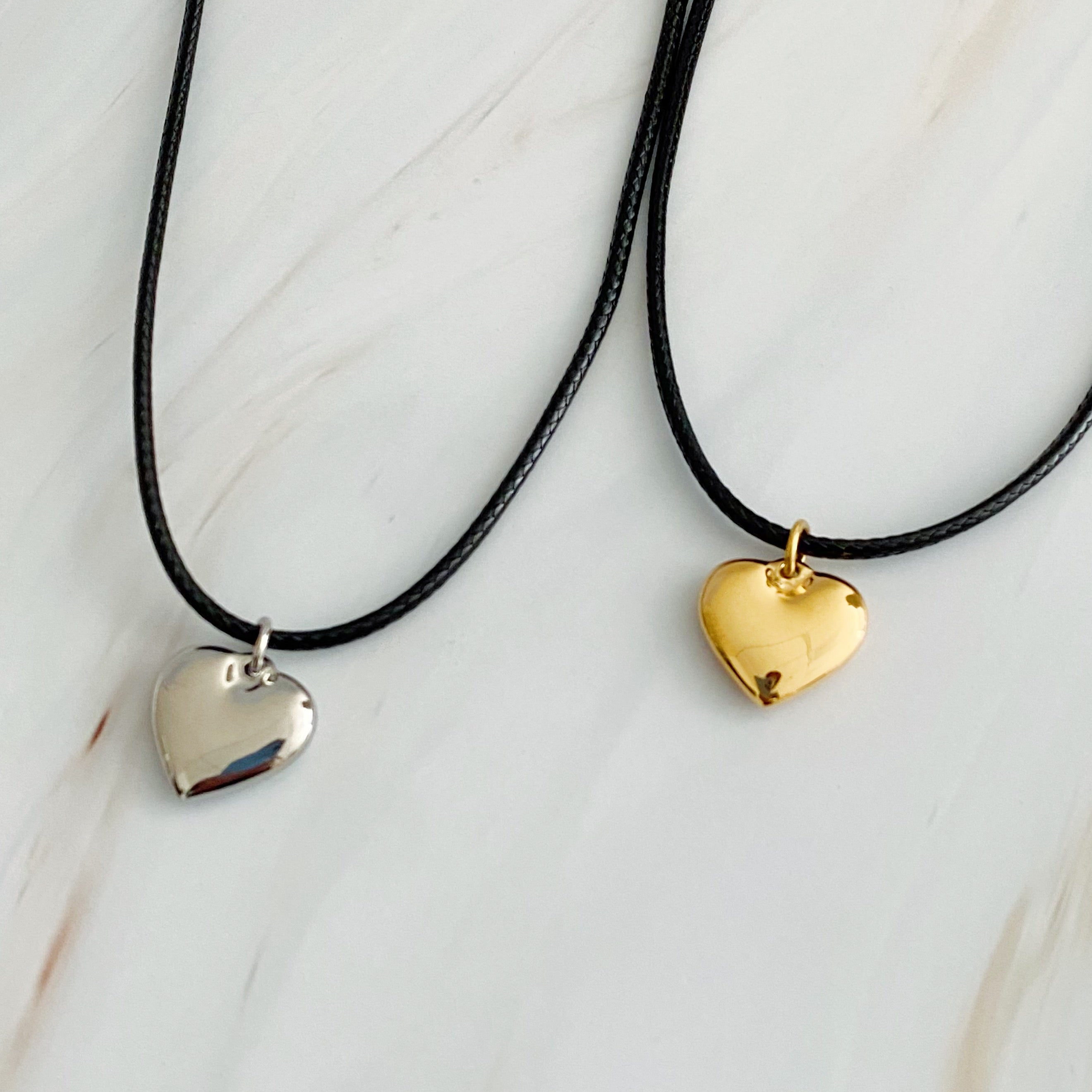 Black Cord Heart Drop Necklace featuring a stylish black cord chain and a rounded heart pendant, elegantly designed for versatile wear.