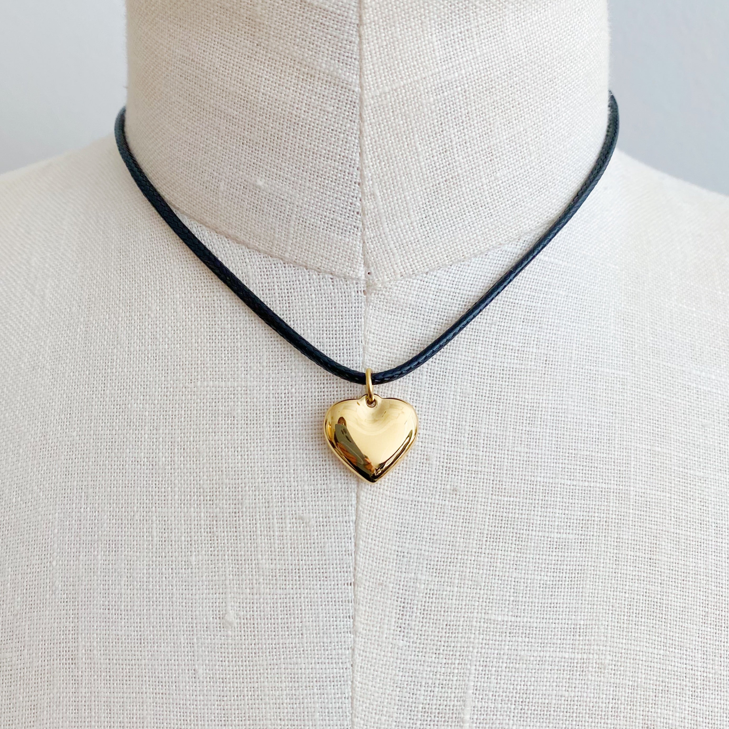 Black Cord Heart Drop Necklace featuring a stylish black cord chain and a rounded heart pendant, elegantly designed for versatile wear.