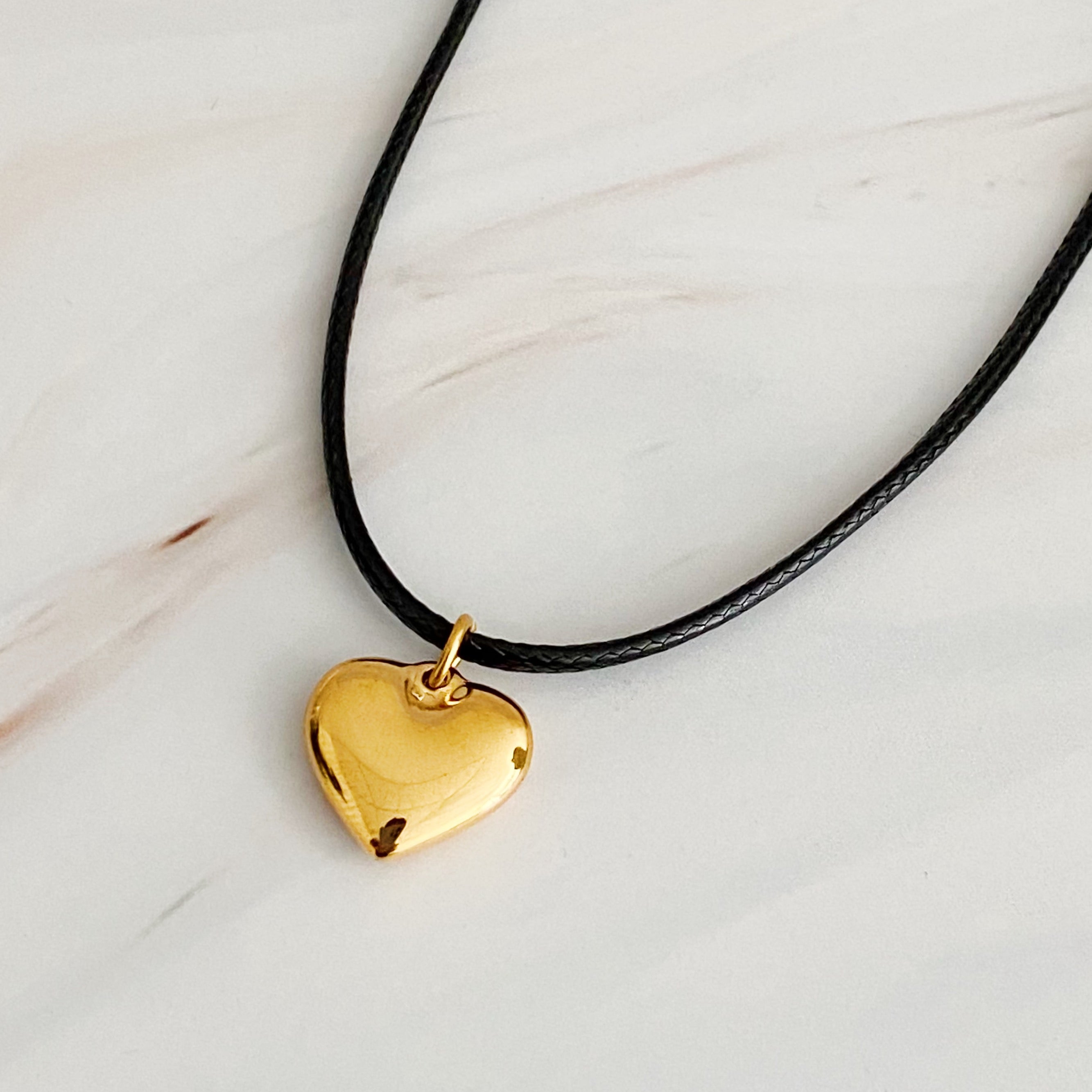 Black Cord Heart Drop Necklace featuring a stylish black cord chain and a rounded heart pendant, elegantly designed for versatile wear.