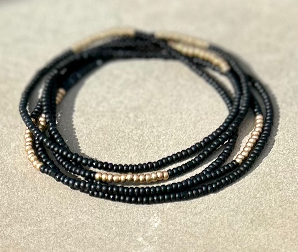 Black and gold striped beaded wrap bracelet made of glass seed beads, showcasing a stylish design suitable for wrist or neck wear.