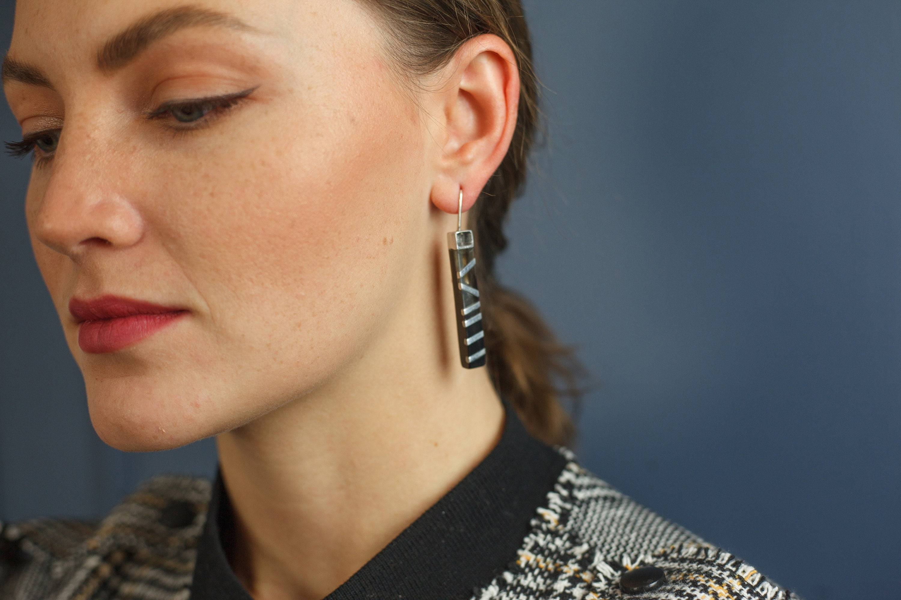 A pair of elegant black horn and aluminum earrings with a 925 sterling silver ear lock, showcasing a unique and stylish design.