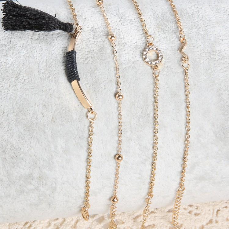 Black Tassel Pav'e 5 Piece Bracelet Set featuring 14K gold plating, black tassel design, and white crystal pav'e accents.