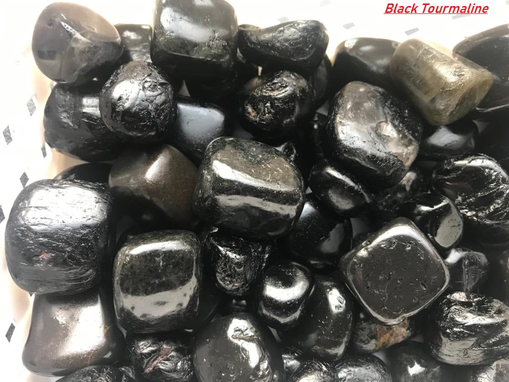 A collection of smooth Black Tourmaline Tumble Stones showcasing their deep black color and natural shine, perfect for energy cleansing.