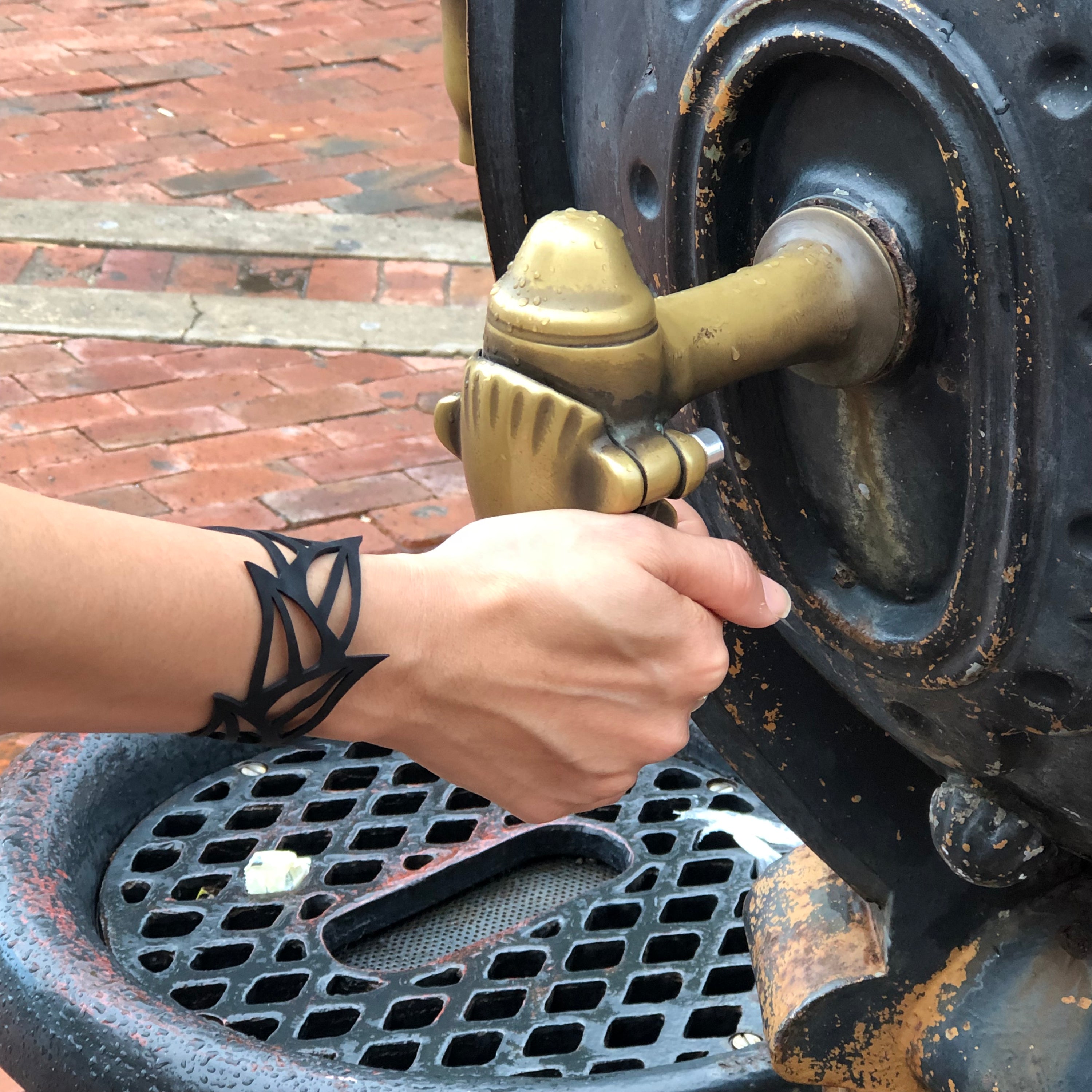 Black Tulip Rubber Bracelet made from reclaimed tyre inner tubes, featuring a floral design and a plastic button clasp.