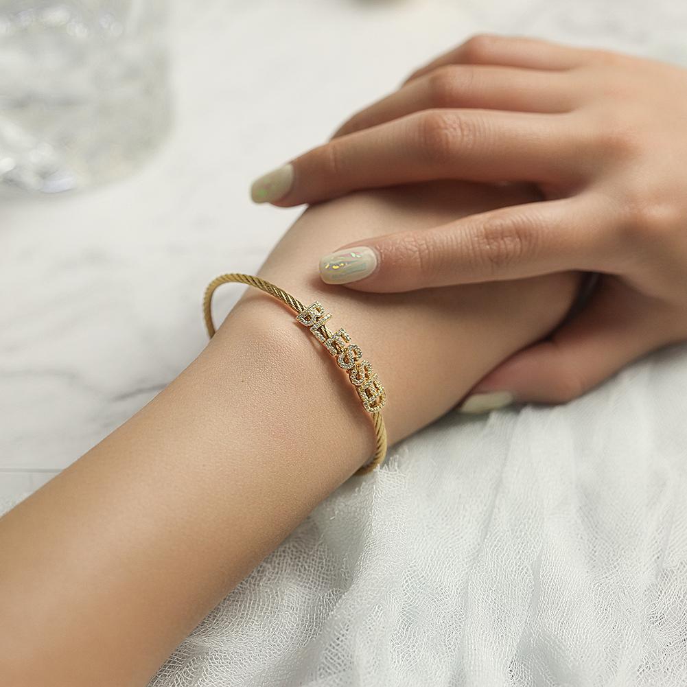 A close-up of the 'BLESSED' Statement Pavé Bracelet showcasing its elegant design and 14K gold PVD plating.