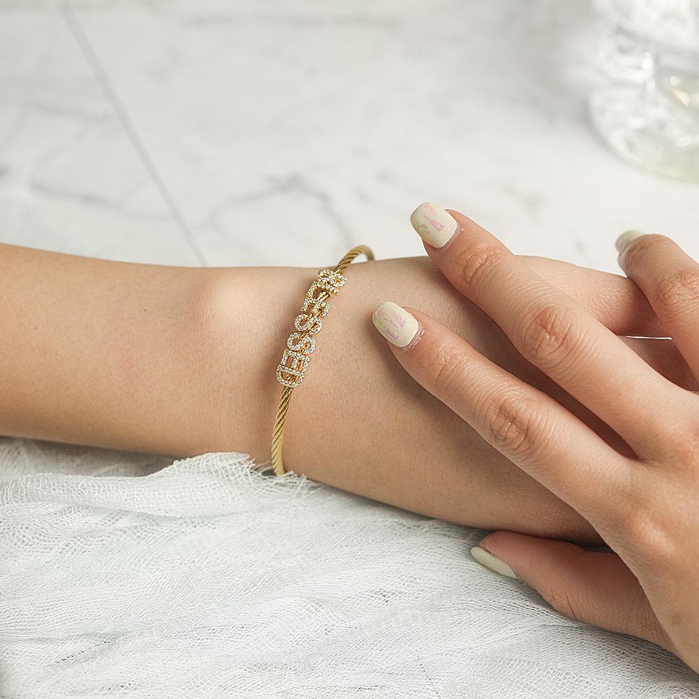 A close-up of the 'BLESSED' Statement Pavé Bracelet showcasing its elegant design and 14K gold PVD plating.