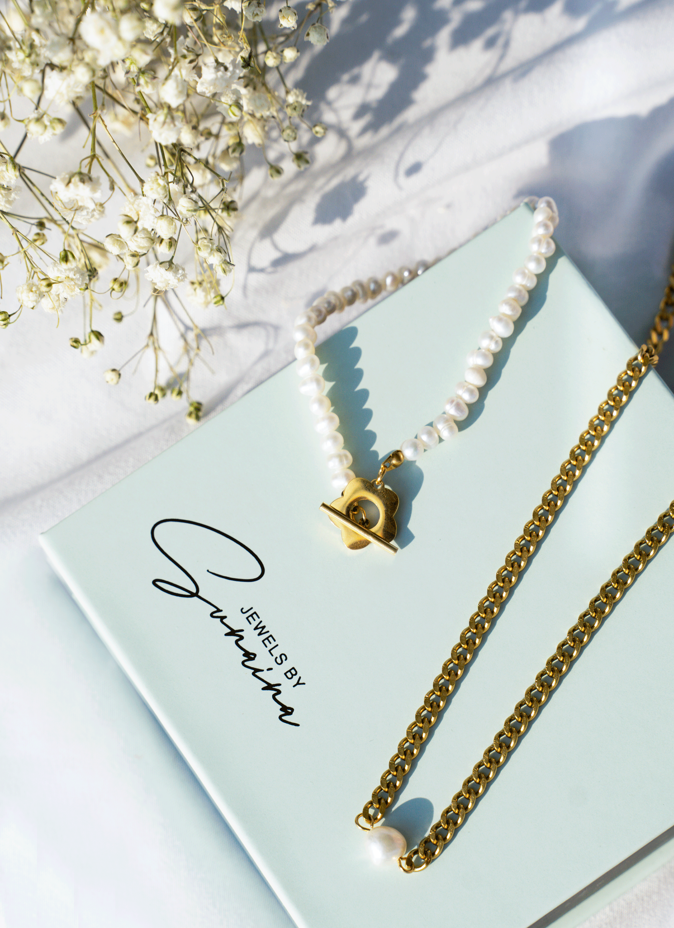 A stylish Blossom Bracelet featuring white freshwater pearls and an 18k gold plated blossom toggle clasp, elegantly displayed.