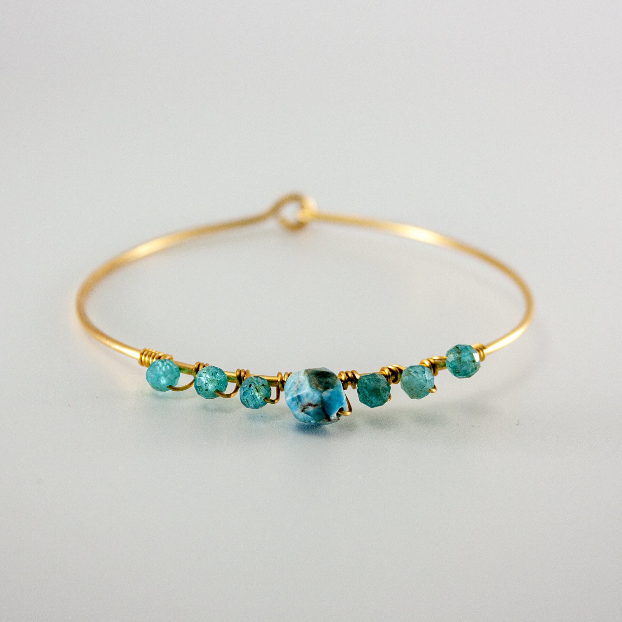 A beautiful blue apatite beaded gold bangle featuring 4mm and 8mm apatite stones, set in a gold-plated brass design.