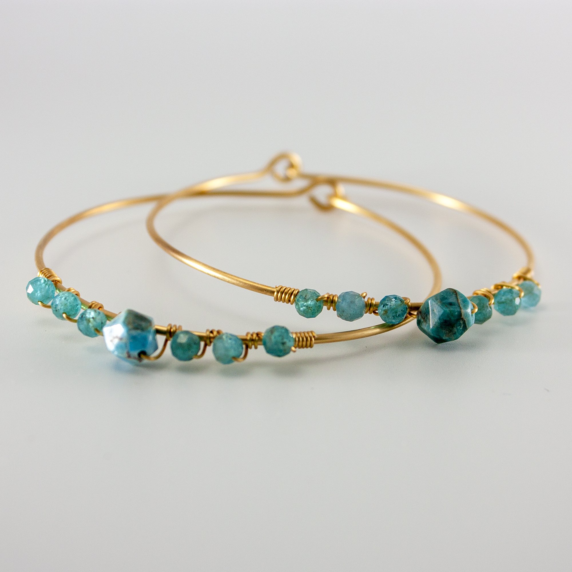 A beautiful blue apatite beaded gold bangle featuring 4mm and 8mm apatite stones, set in a gold-plated brass design.