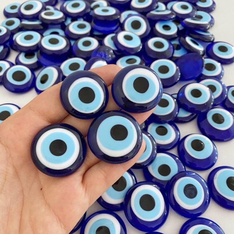 A collection of blue evil eye glass beads without holes, showcasing their vibrant color and intricate design, perfect for weddings and party favors.