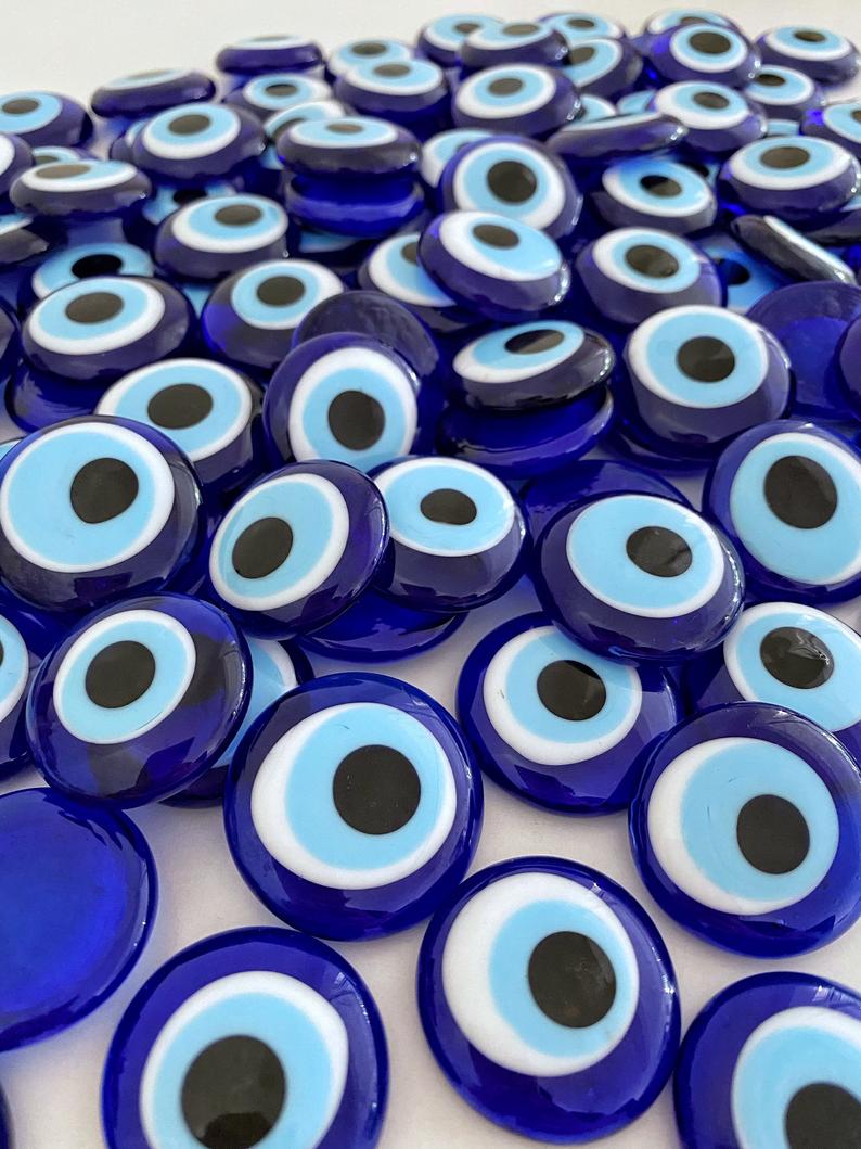 A collection of blue evil eye glass beads without holes, showcasing their vibrant color and intricate design, perfect for weddings and party favors.