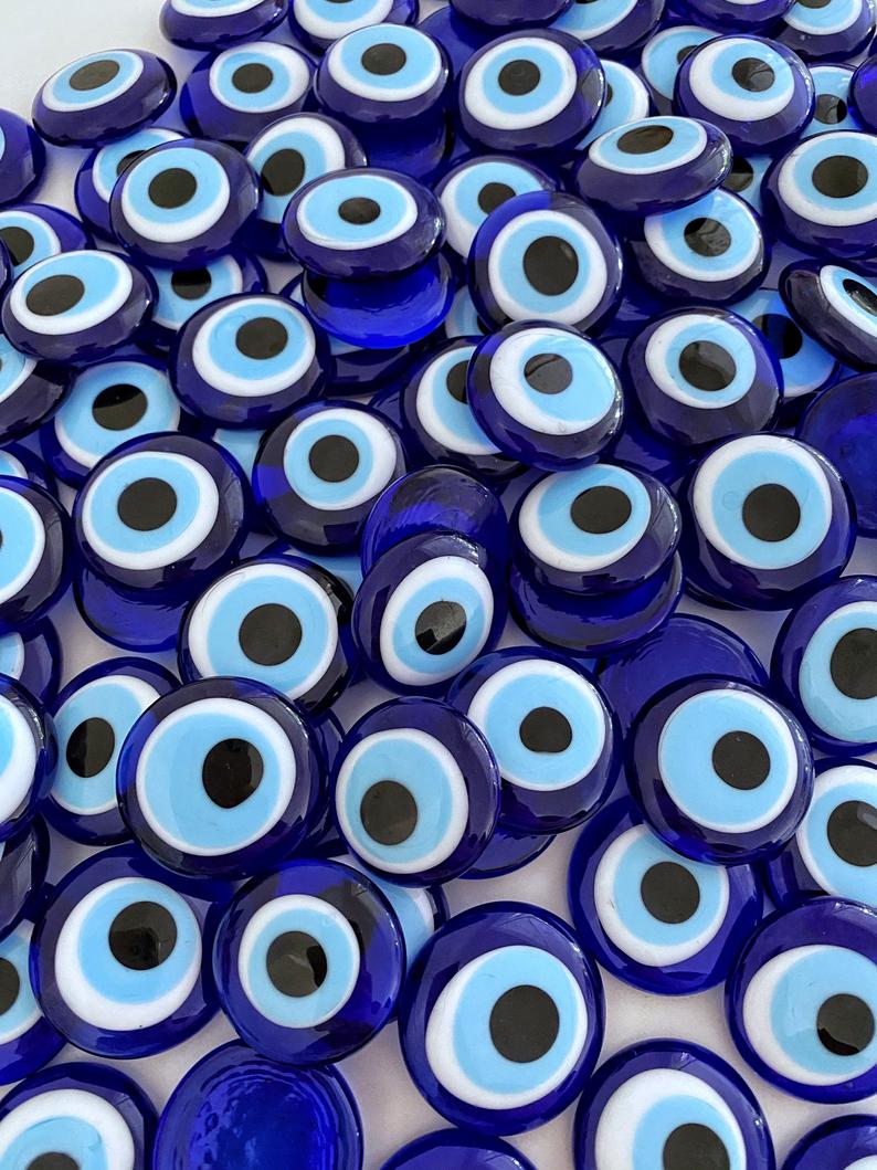 A collection of blue evil eye glass beads without holes, showcasing their vibrant color and intricate design, perfect for weddings and party favors.