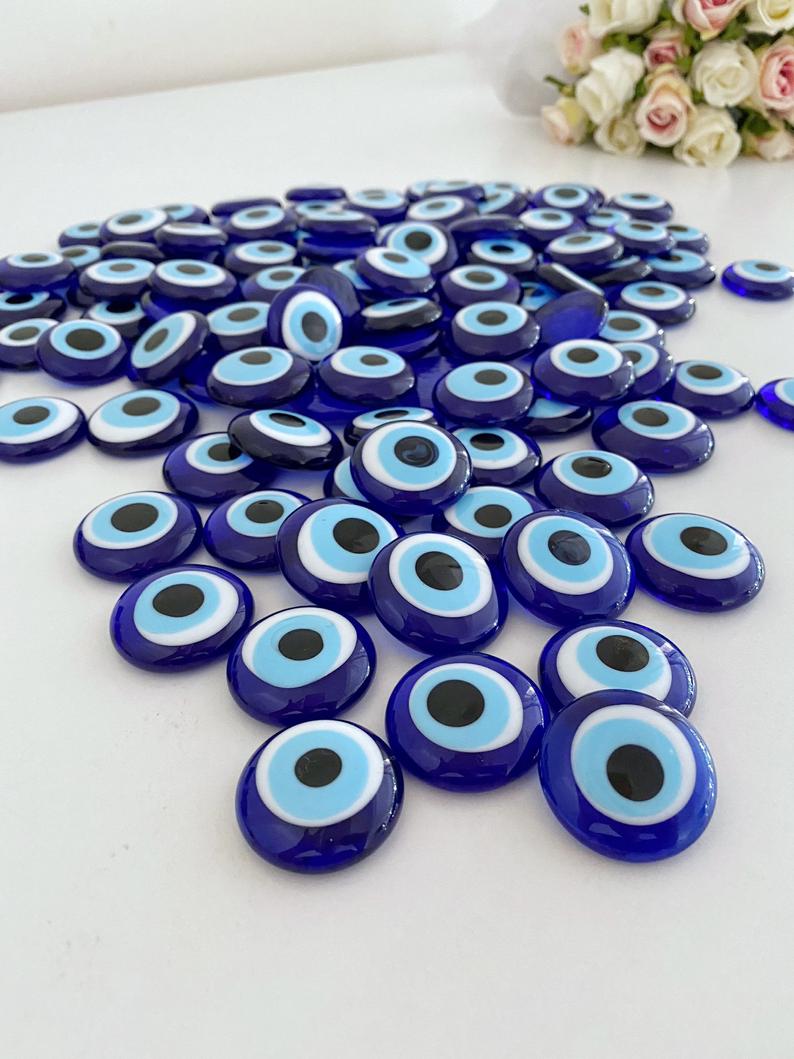 A collection of blue evil eye glass beads without holes, showcasing their vibrant color and intricate design, perfect for weddings and party favors.