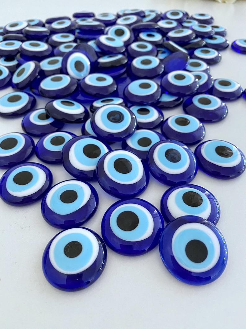 A collection of blue evil eye glass beads without holes, showcasing their vibrant color and intricate design, perfect for weddings and party favors.