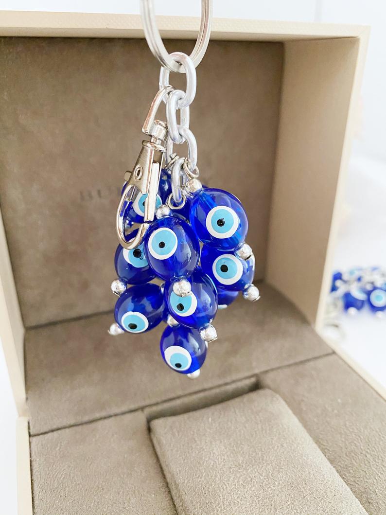 A stylish blue evil eye bead keychain featuring resin beads and an enamel keychain, symbolizing protection and good luck.