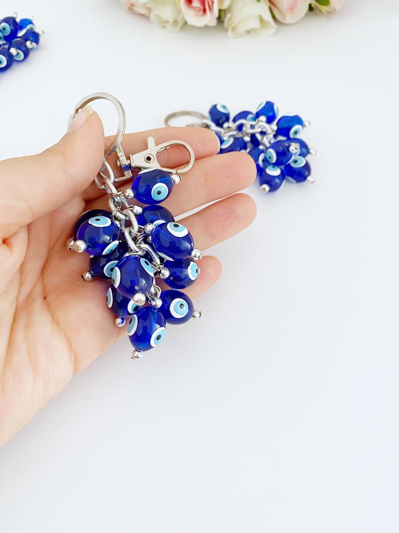 A stylish blue evil eye bead keychain featuring resin beads and an enamel keychain, symbolizing protection and good luck.