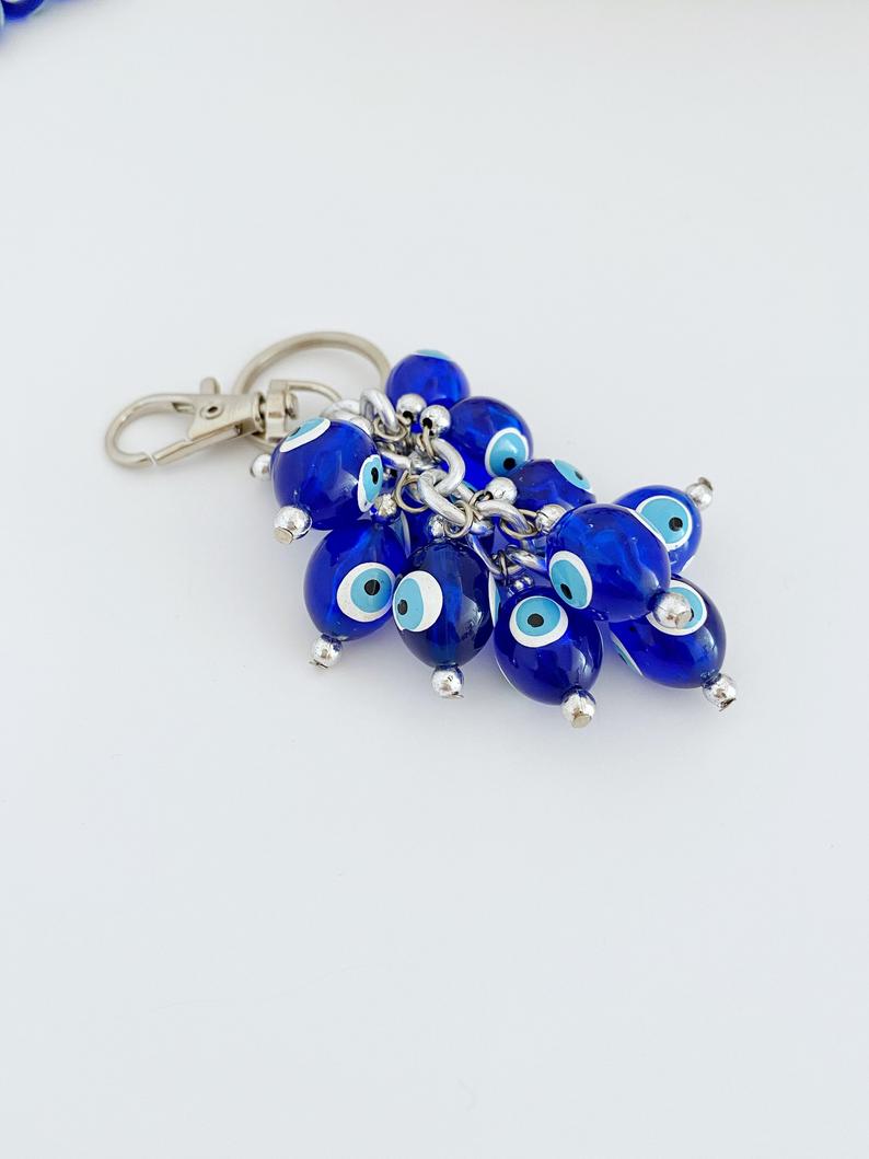 A stylish blue evil eye bead keychain featuring resin beads and an enamel keychain, symbolizing protection and good luck.