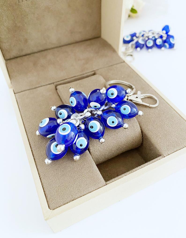 A stylish blue evil eye bead keychain featuring resin beads and an enamel keychain, symbolizing protection and good luck.