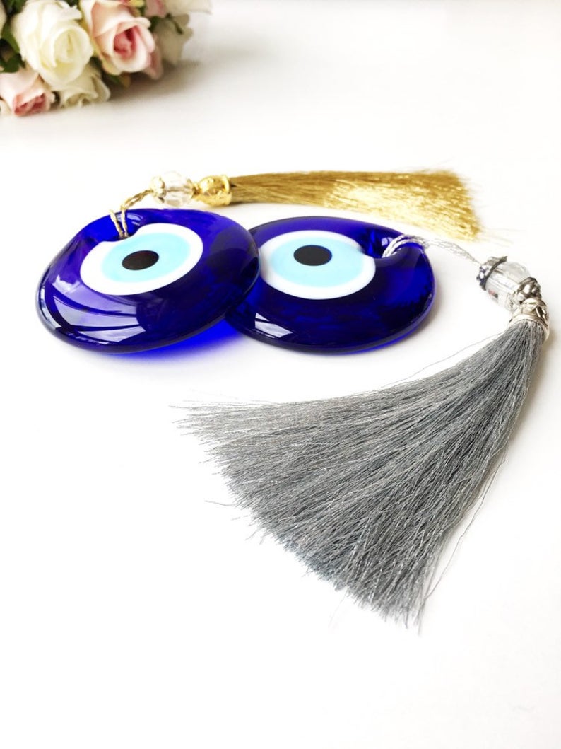 A collection of 7cm blue evil eye beads with tassels, showcasing their vibrant color and intricate design, perfect for wedding favors.