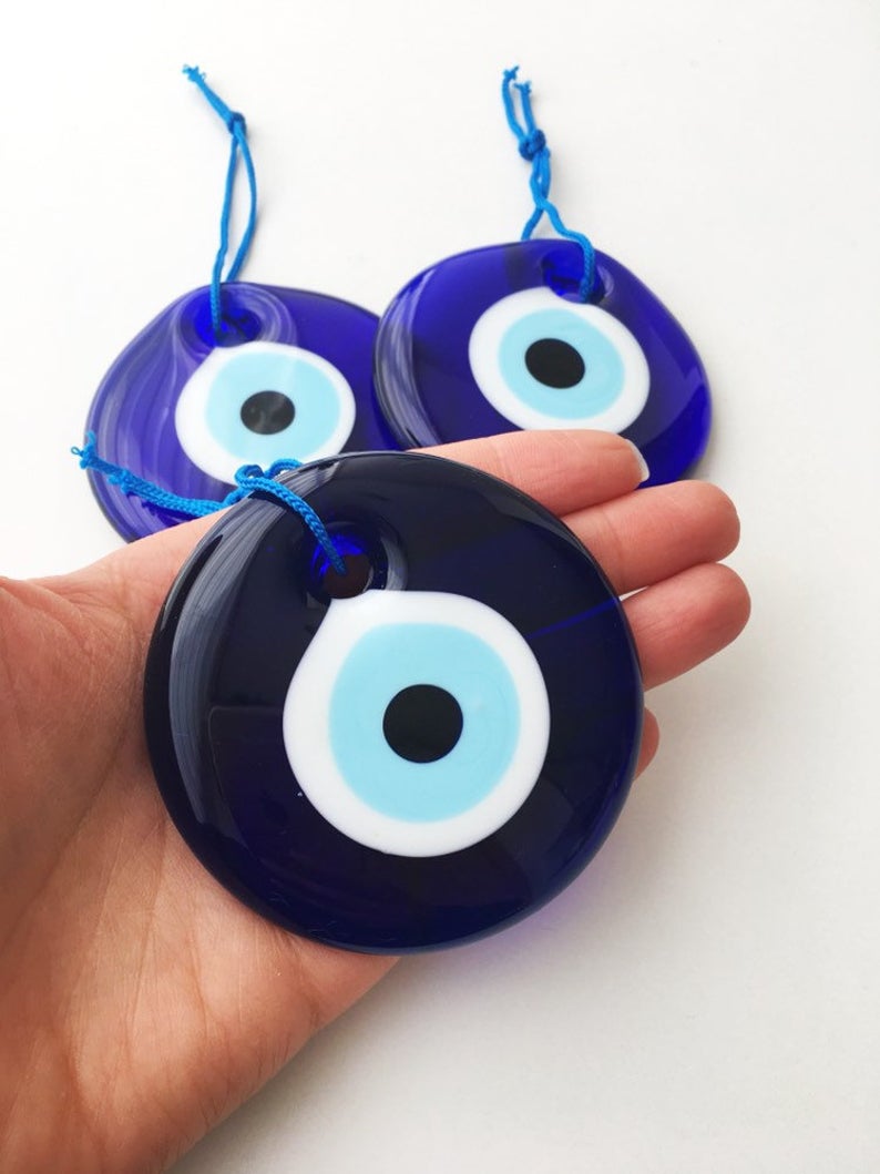 A collection of 7cm blue evil eye beads with tassels, showcasing their vibrant color and intricate design, perfect for wedding favors.