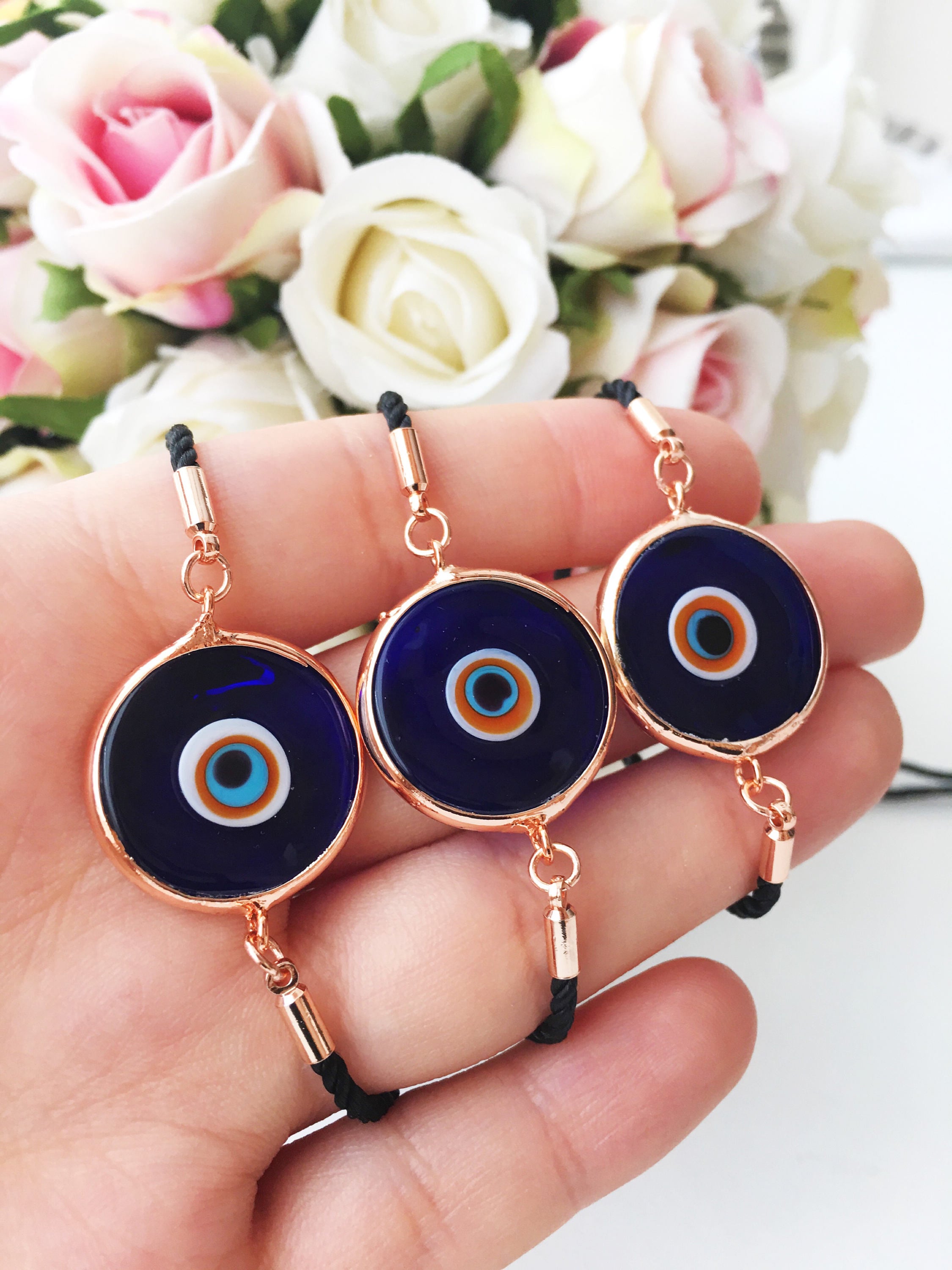 A beautiful blue evil eye bracelet made of Murano glass, featuring an adjustable black and white string, showcasing its unique charm and craftsmanship.