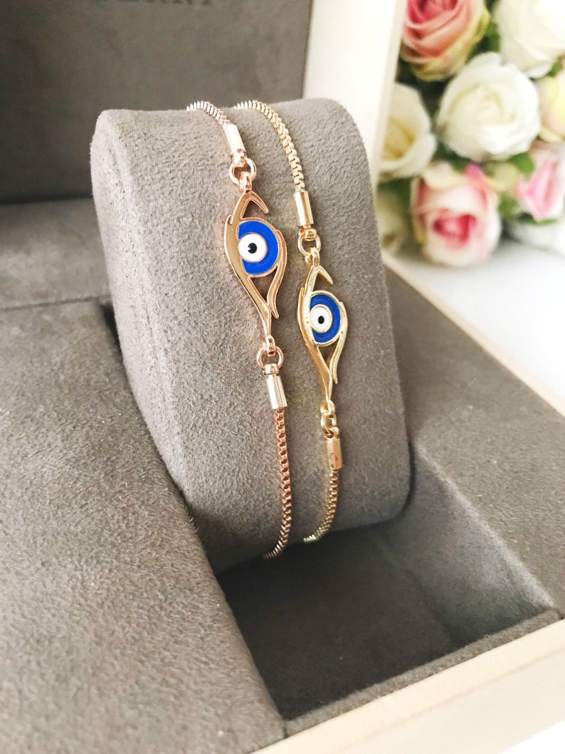 A beautiful blue evil eye bracelet in rose gold, featuring an adjustable design and a striking evil eye charm.