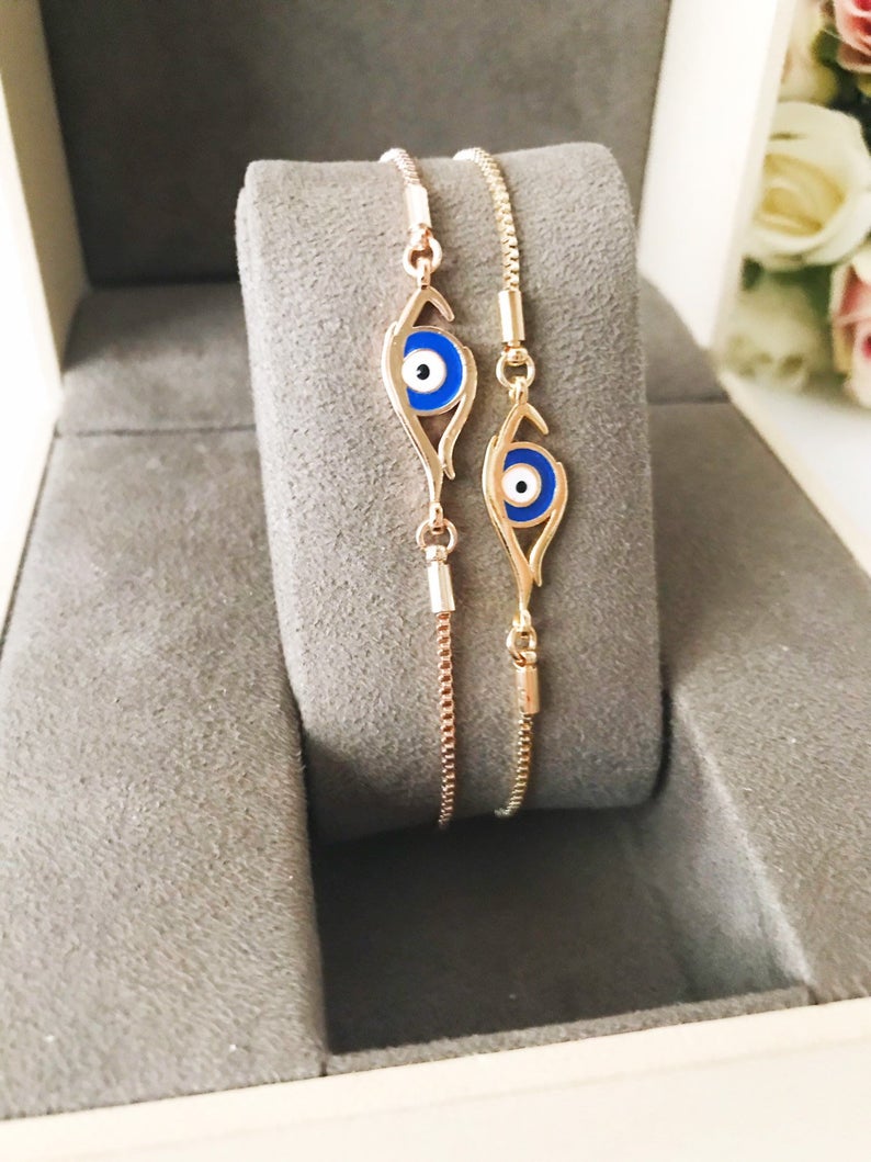 A beautiful blue evil eye bracelet in rose gold, featuring an adjustable design and a striking evil eye charm.