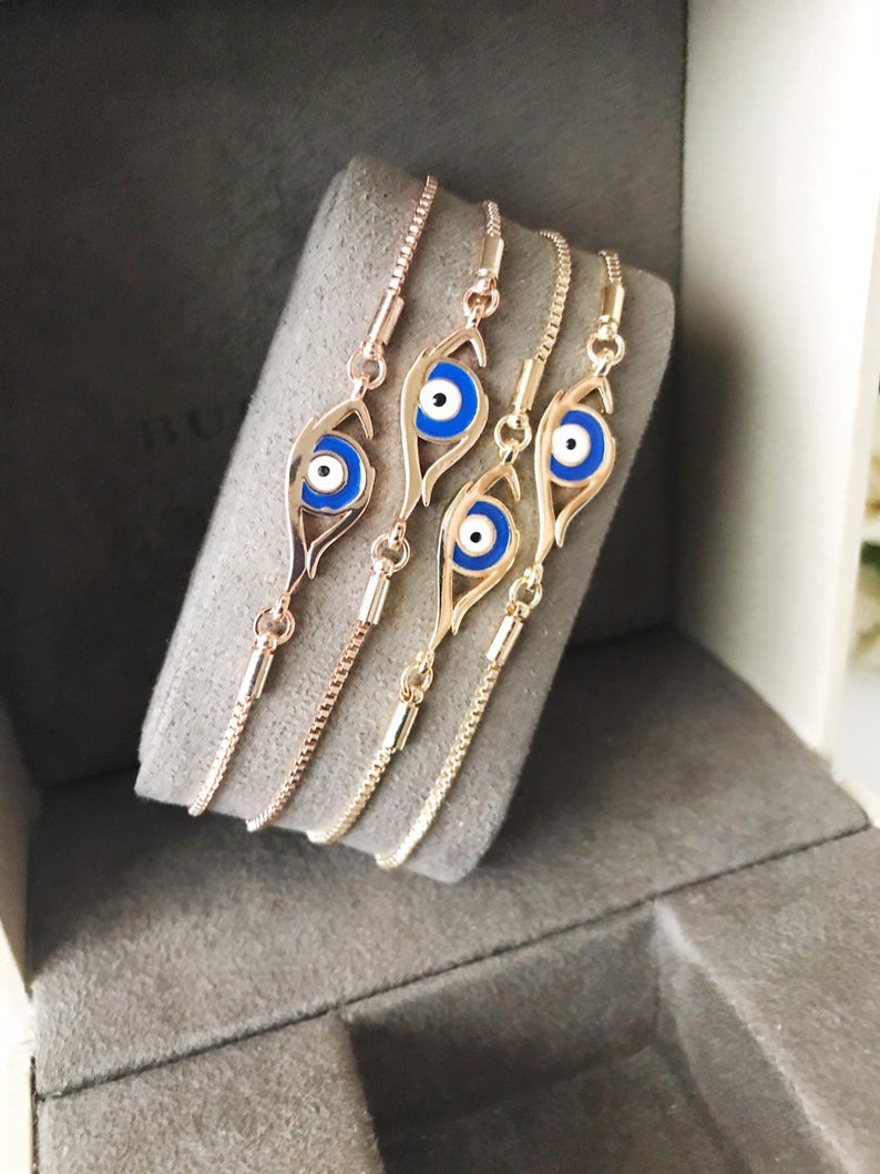 A beautiful blue evil eye bracelet in rose gold, featuring an adjustable design and a striking evil eye charm.