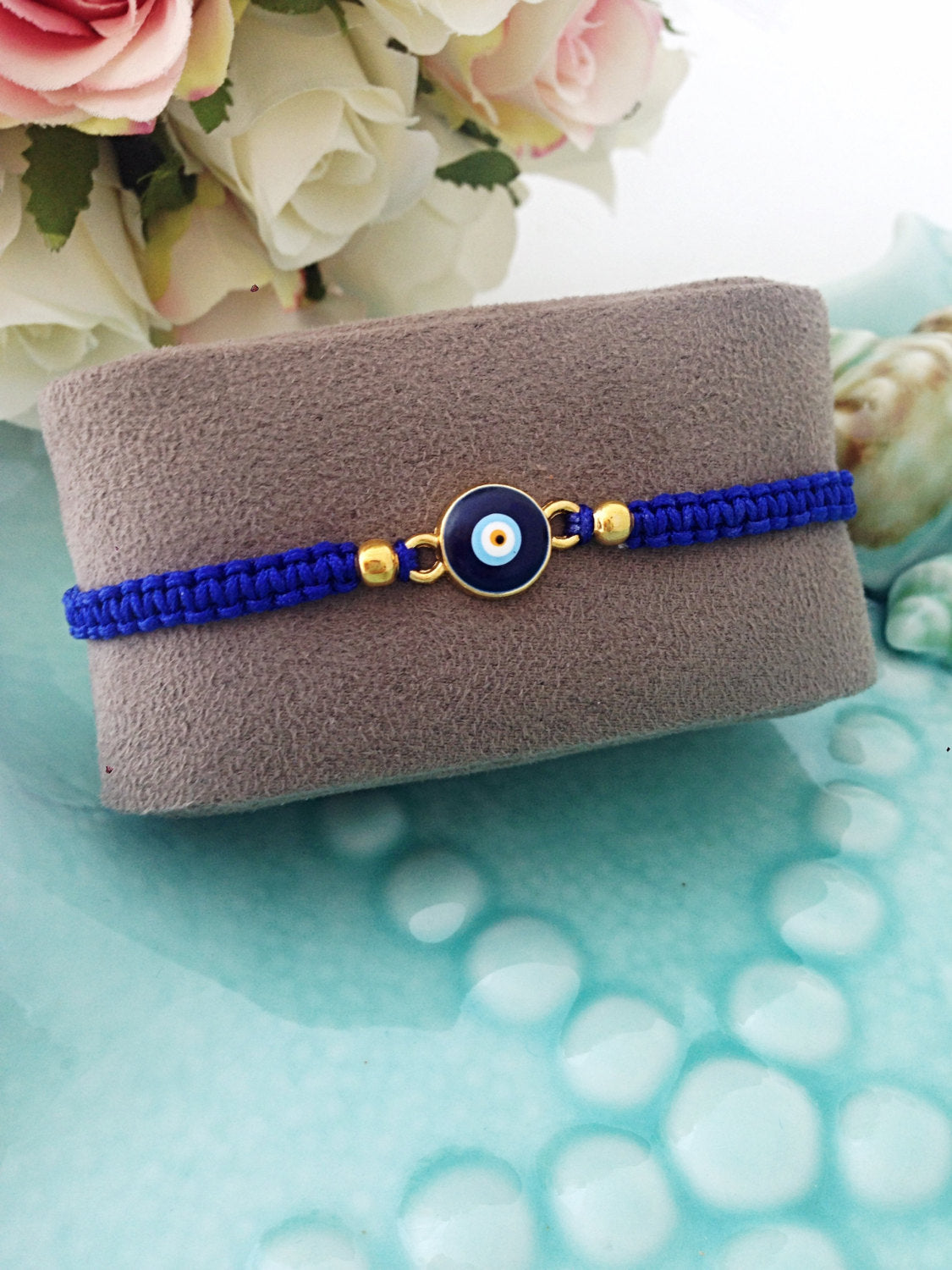 Handmade blue evil eye bracelet featuring an adjustable black macramé design with a blue evil eye charm.