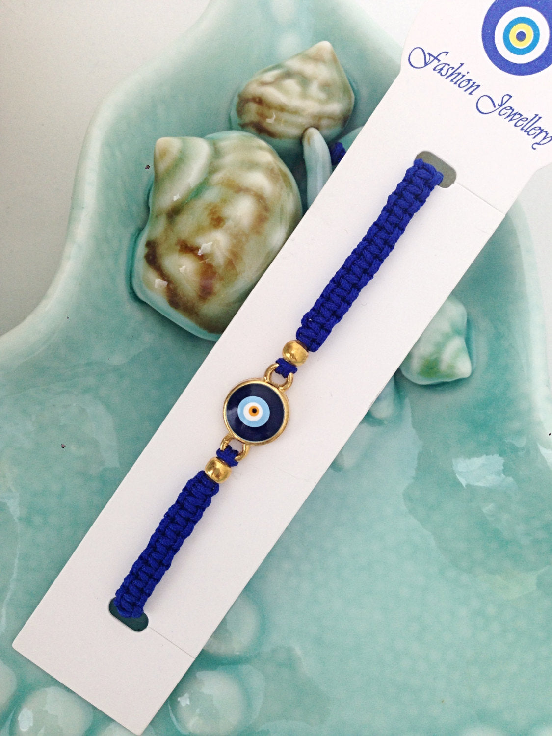 Handmade blue evil eye bracelet featuring an adjustable black macramé design with a blue evil eye charm.