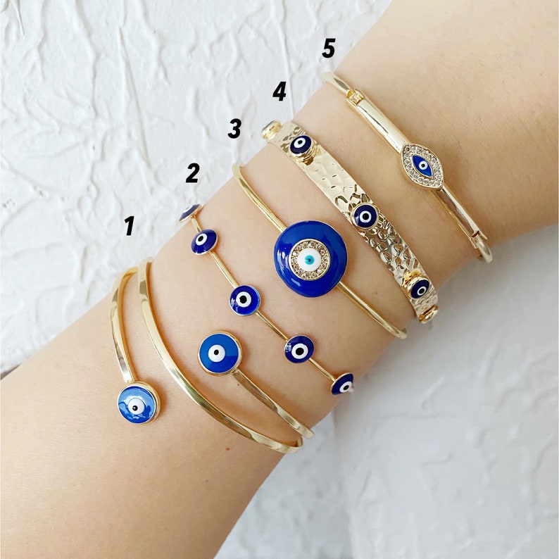 A beautiful handmade Blue Evil Eye Bracelet featuring a gold cuff design, showcasing intricate details and a protective blue eye symbol.