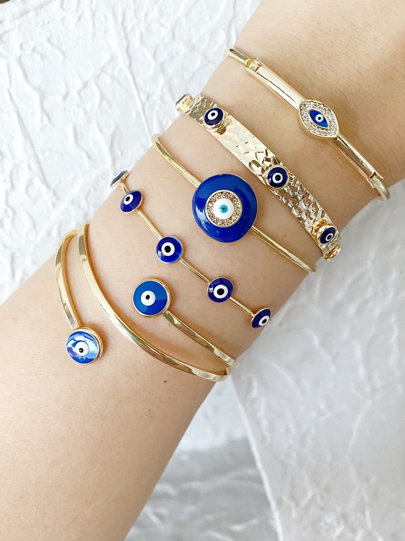 A beautiful handmade Blue Evil Eye Bracelet featuring a gold cuff design, showcasing intricate details and a protective blue eye symbol.