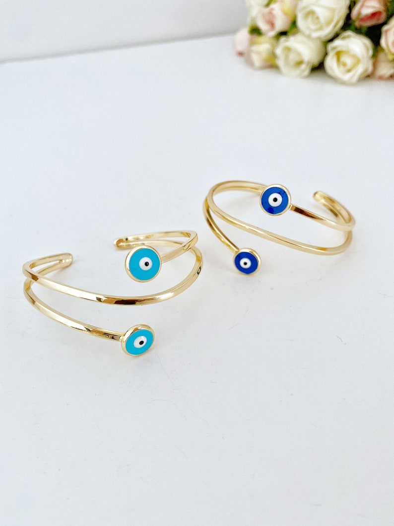 A beautiful handmade Blue Evil Eye Bracelet featuring a gold cuff design, showcasing intricate details and a protective blue eye symbol.