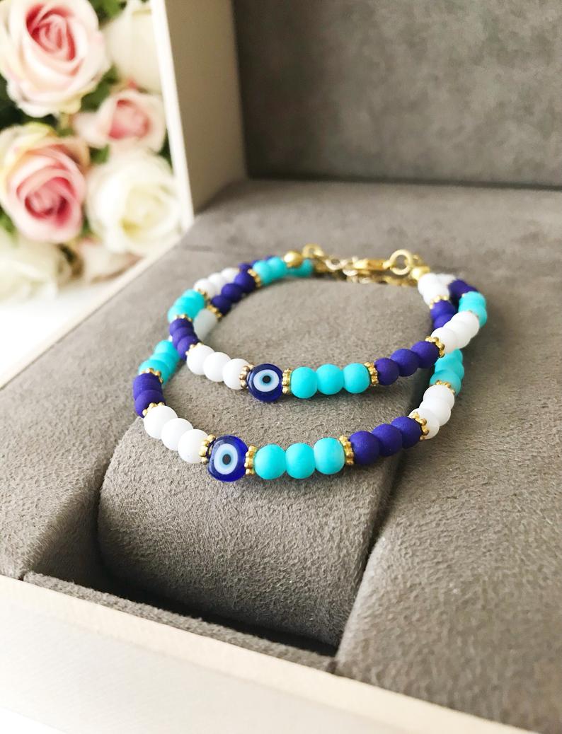 Handmade Blue Evil Eye Bracelet featuring ceramic and glass beads, adjustable design for comfort, symbolizing luck and protection.