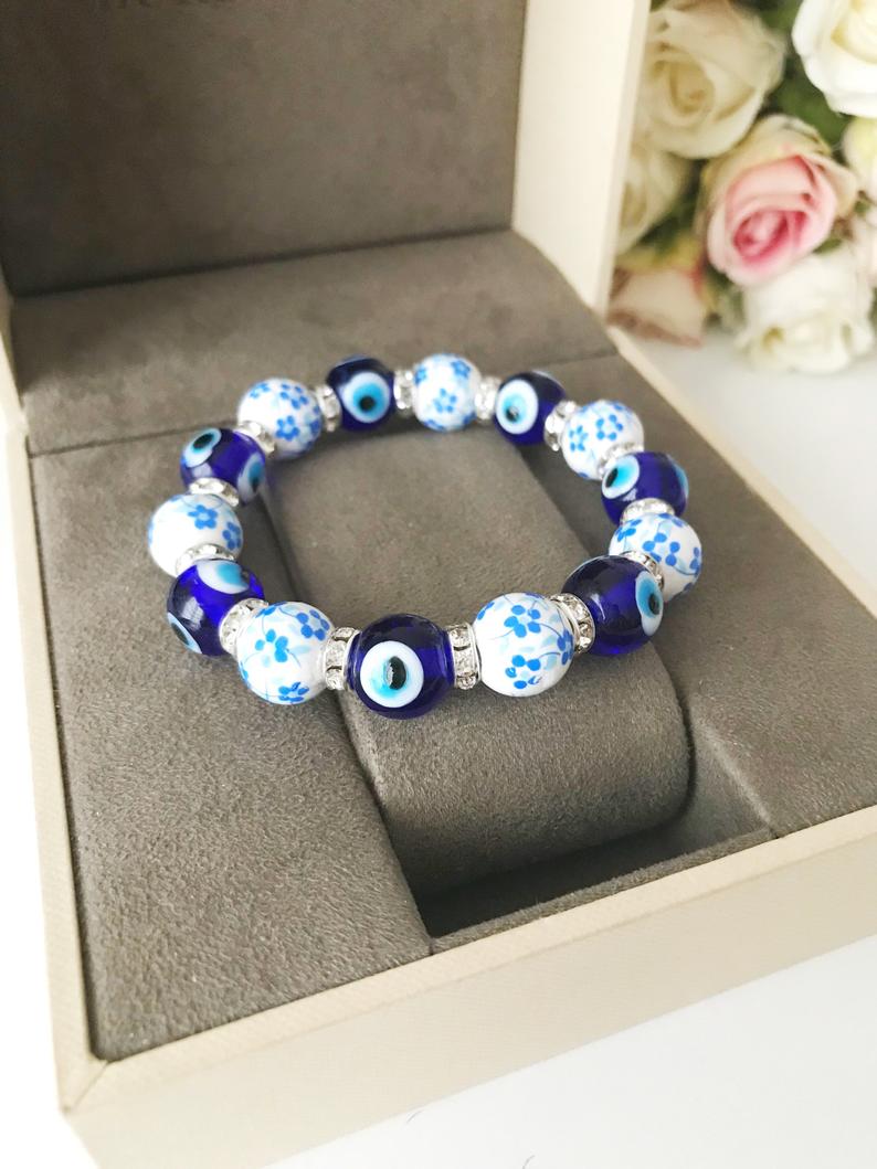 Handmade Blue Evil Eye Bracelet featuring ceramic and glass beads, adjustable design for comfort, symbolizing luck and protection.