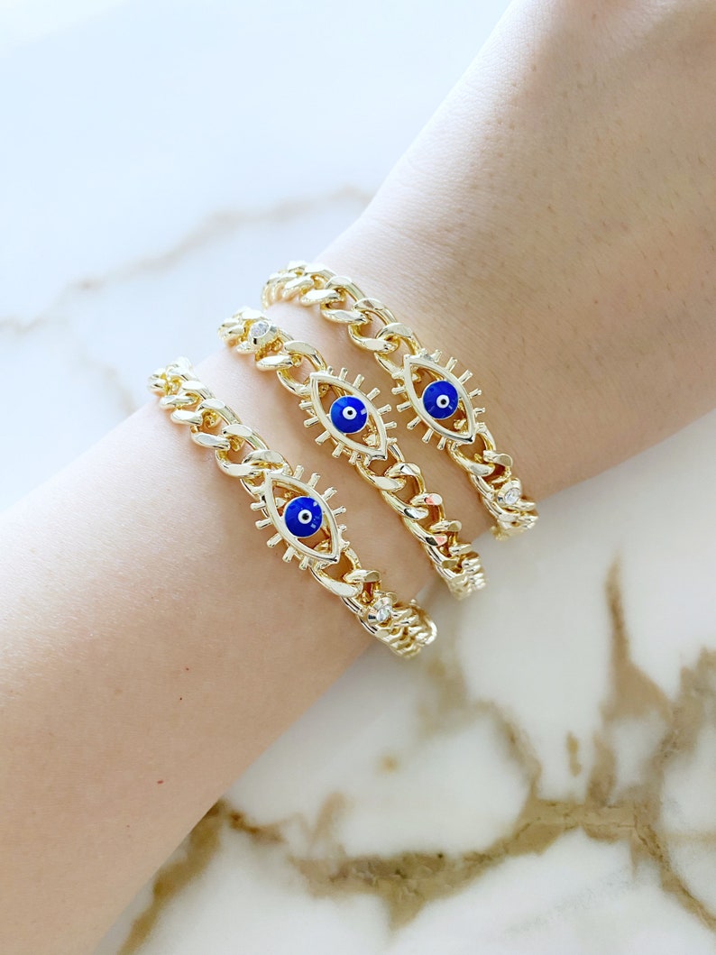 A stylish blue evil eye bracelet made of tarnish-resistant gold stainless steel, featuring a curb chain design and an adjustable fit.