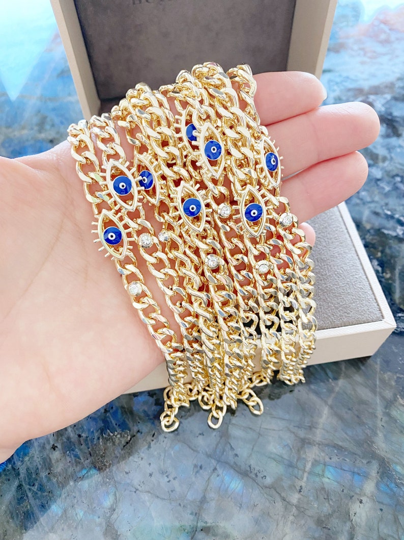 A stylish blue evil eye bracelet made of tarnish-resistant gold stainless steel, featuring a curb chain design and an adjustable fit.