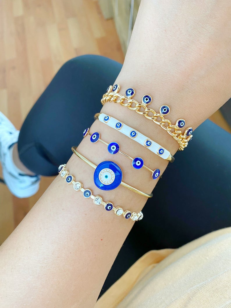 A beautiful blue evil eye bracelet made of gold stainless steel, showcasing its intricate design and water-resistant features.