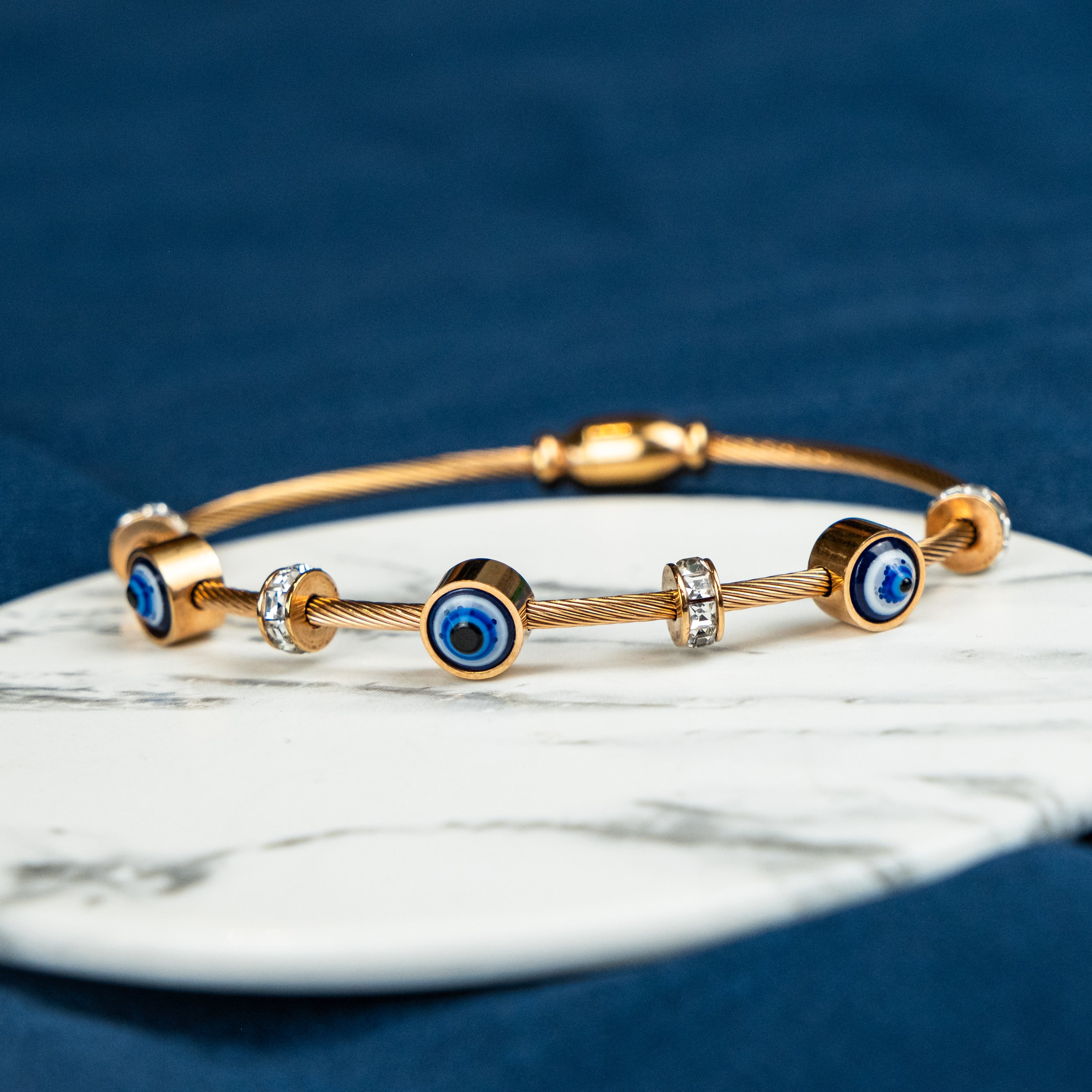 Blue Evil Eye Brass Gold Zircon Magnetic Bangle Bracelet featuring three evil eye charms in a radiant rose gold finish.