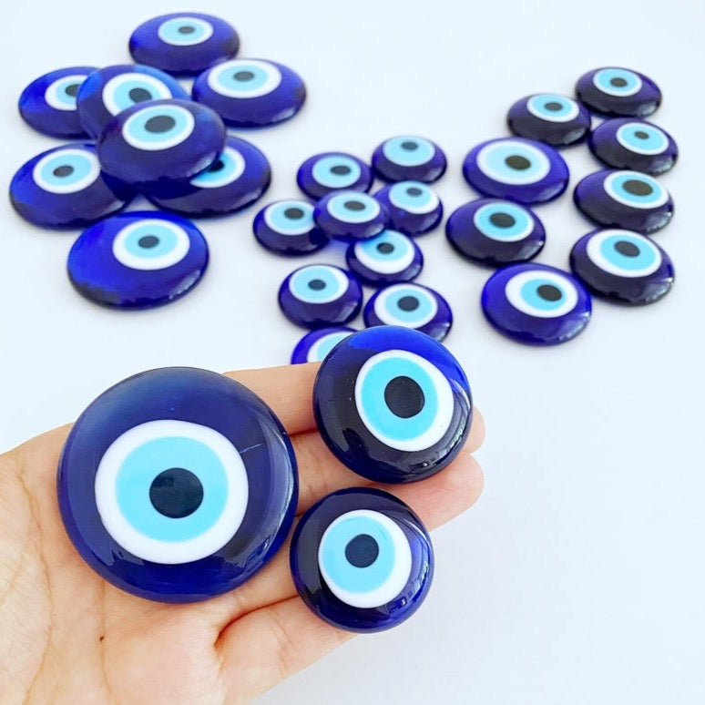 A collection of 10 blue glass evil eye beads without holes, showcasing various sizes from 3 to 5.5 cm, perfect for crafts and decorations.