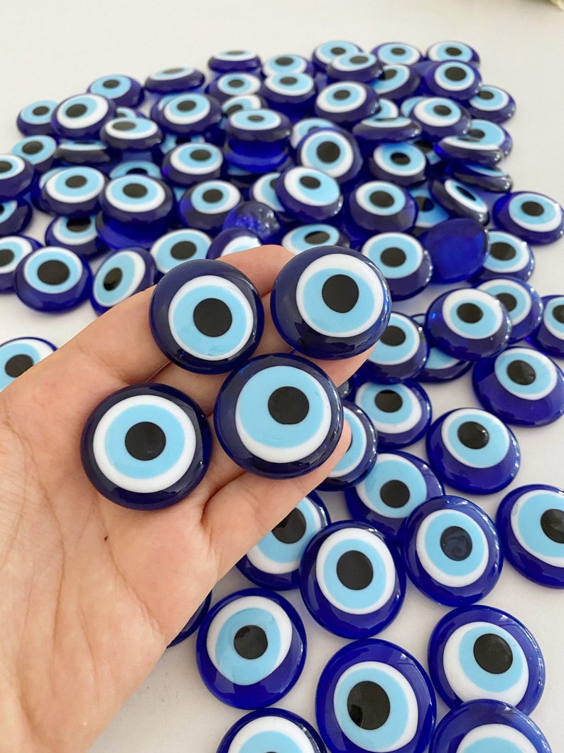 A collection of 10 blue glass evil eye beads without holes, showcasing various sizes from 3 to 5.5 cm, perfect for crafts and decorations.