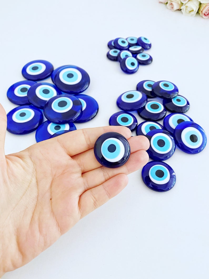 A collection of 10 blue glass evil eye beads without holes, showcasing various sizes from 3 to 5.5 cm, perfect for crafts and decorations.