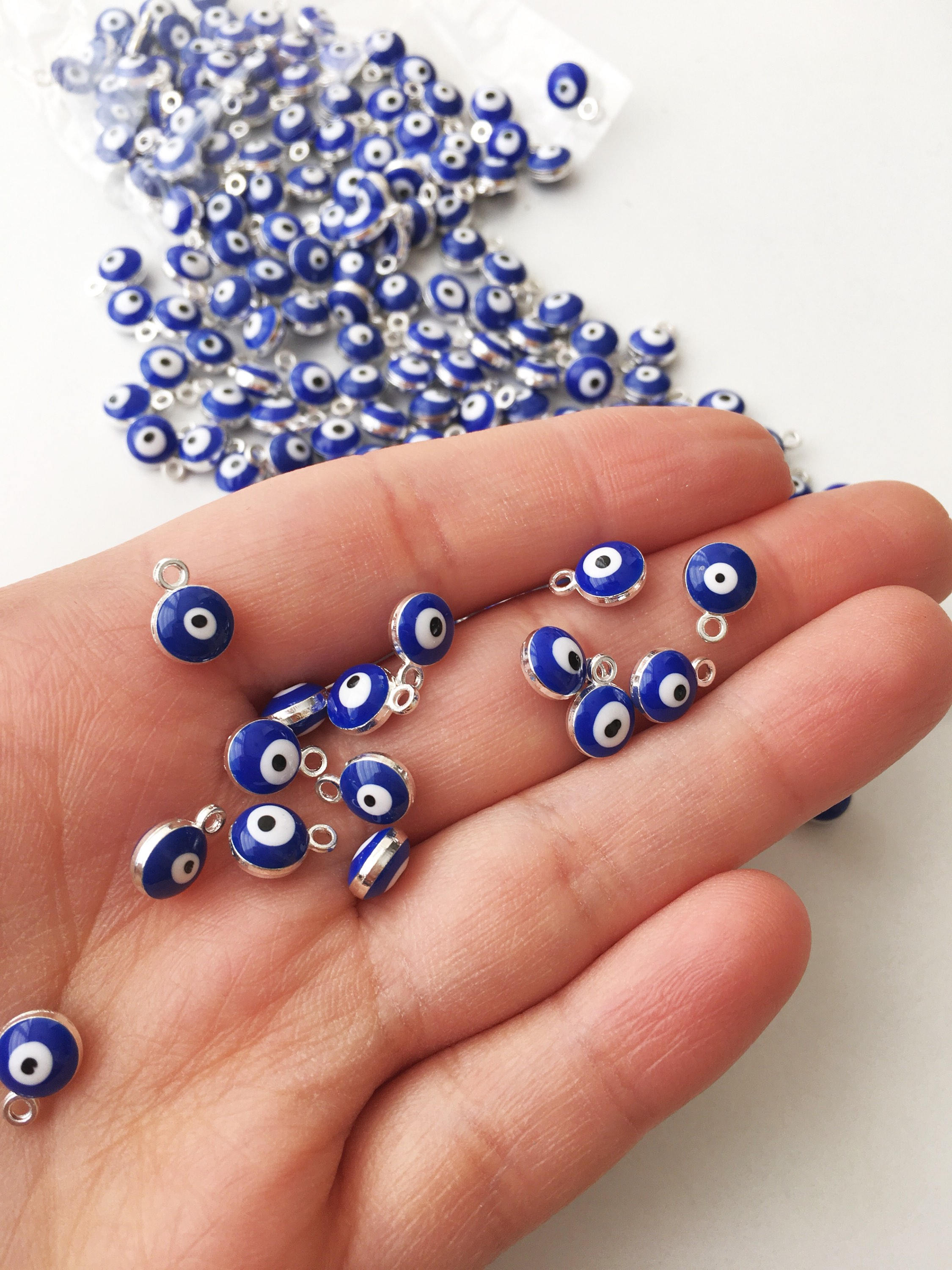 A collection of 10 blue evil eye charms made from brass, featuring a glossy enamel finish and a 2-sided design.